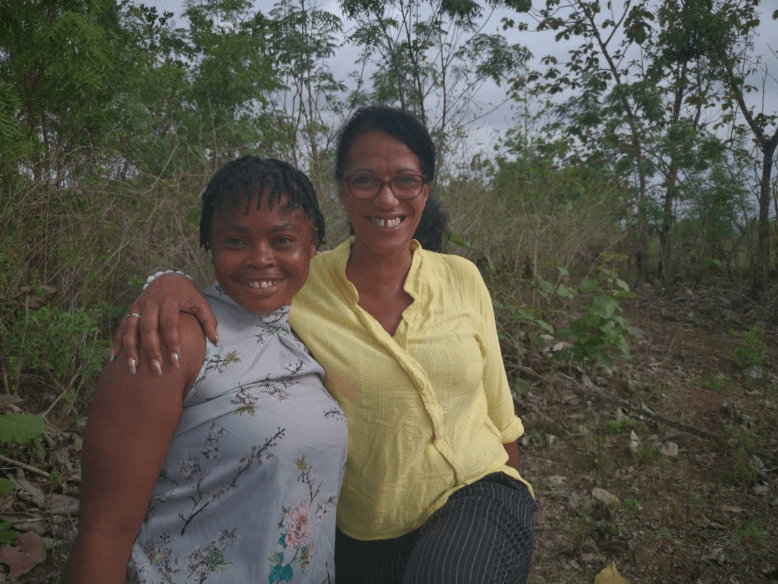 Two women farmers standing together in a natural setting